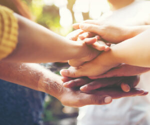 Diverse hands stacked in celebration.